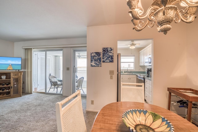 dining space featuring ceiling fan, sink, and carpet