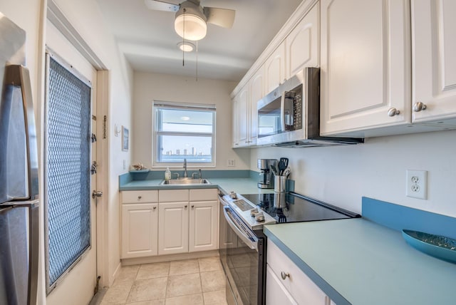 kitchen featuring white cabinets, sink, ceiling fan, light tile patterned floors, and stainless steel appliances