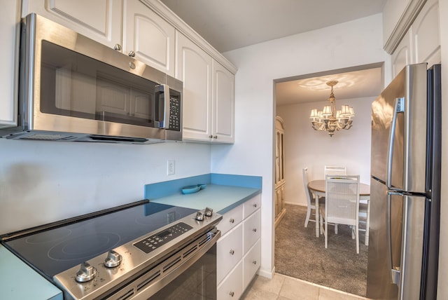 kitchen with light carpet, an inviting chandelier, white cabinets, decorative light fixtures, and stainless steel appliances