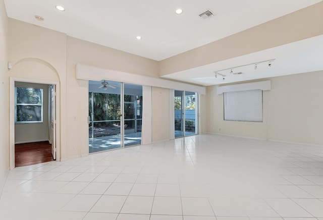 tiled empty room featuring ceiling fan and track lighting