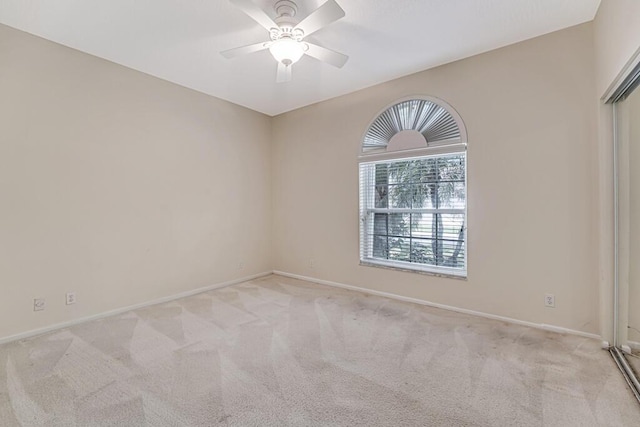 carpeted spare room featuring ceiling fan