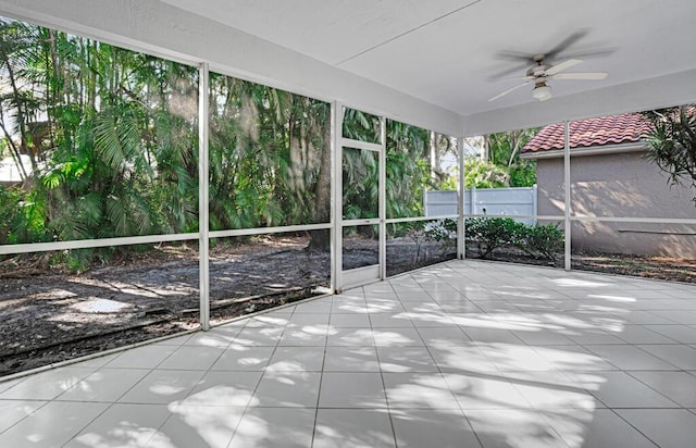 unfurnished sunroom featuring ceiling fan