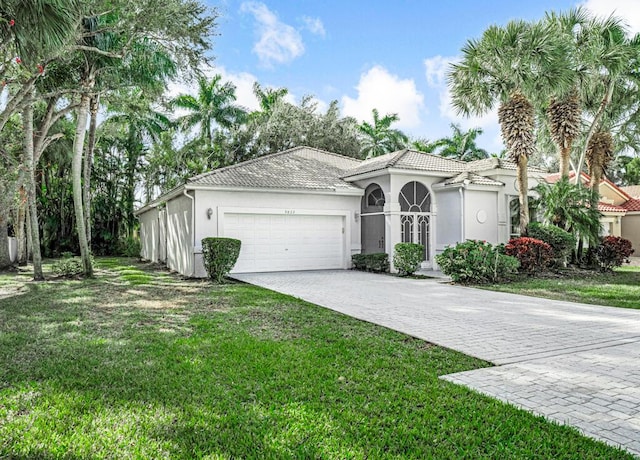 mediterranean / spanish home featuring a front yard and a garage