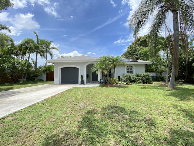 ranch-style home with a front yard, solar panels, and a garage