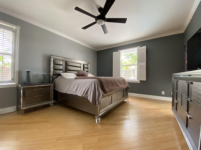 bedroom featuring ceiling fan, light hardwood / wood-style floors, crown molding, and multiple windows