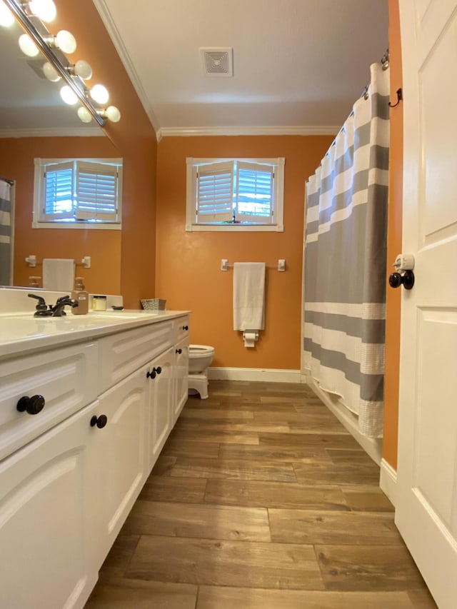 bathroom featuring hardwood / wood-style floors, vanity, toilet, and ornamental molding