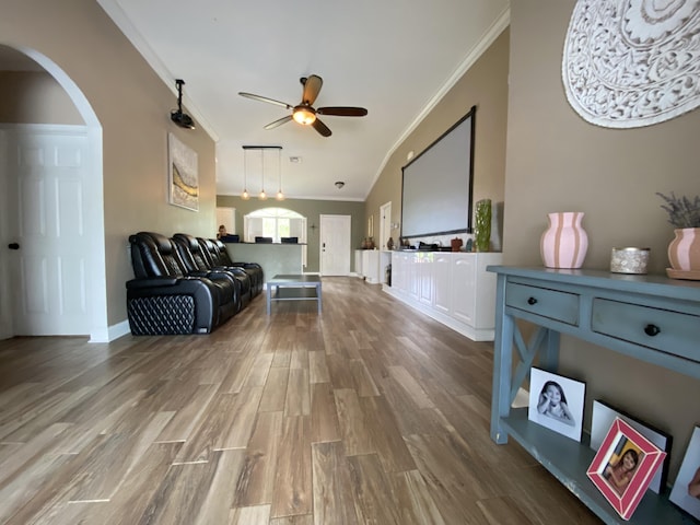 living room with ceiling fan, hardwood / wood-style floors, lofted ceiling, and ornamental molding