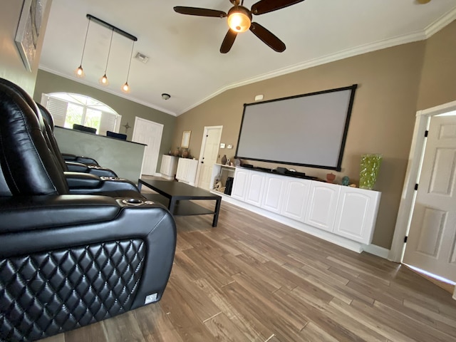 cinema featuring hardwood / wood-style floors, ceiling fan, ornamental molding, and vaulted ceiling