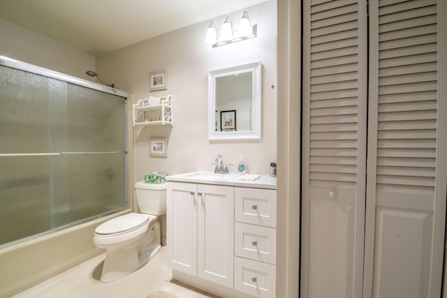 bathroom with toilet, combined bath / shower with glass door, vanity, and a closet