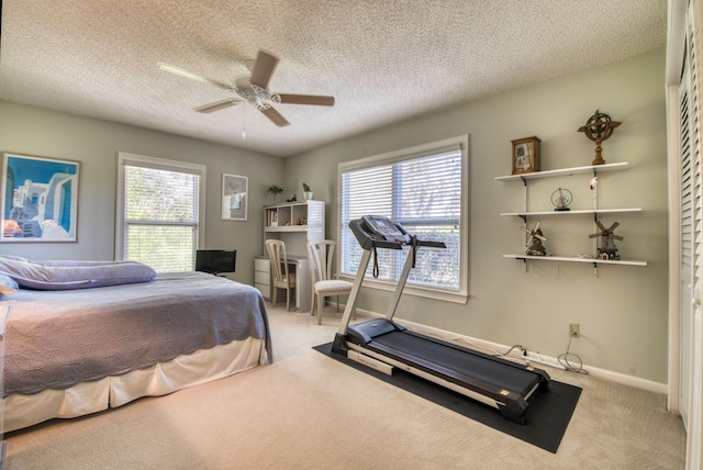 carpeted bedroom featuring multiple windows, ceiling fan, and a textured ceiling