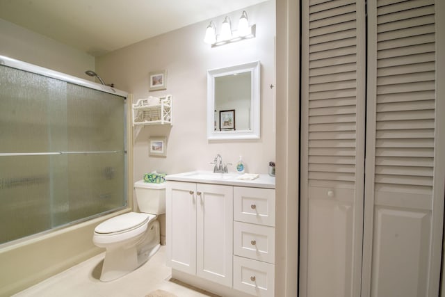 full bathroom featuring shower / bath combination with glass door, tile patterned flooring, vanity, and toilet