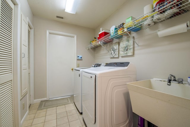 washroom with light tile patterned floors, separate washer and dryer, and sink