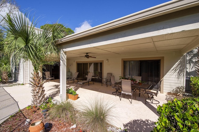 rear view of property with ceiling fan, a patio area, and outdoor dining space