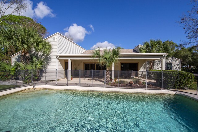rear view of property with fence and a patio