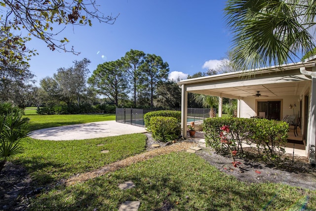 view of yard with a fenced in pool and ceiling fan