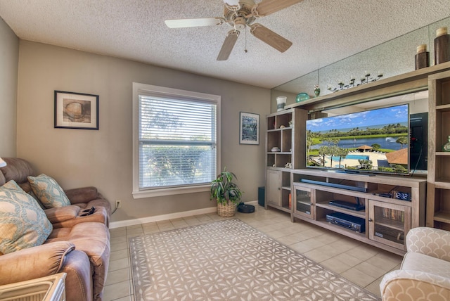 living room featuring ceiling fan, light tile patterned floors, and a textured ceiling