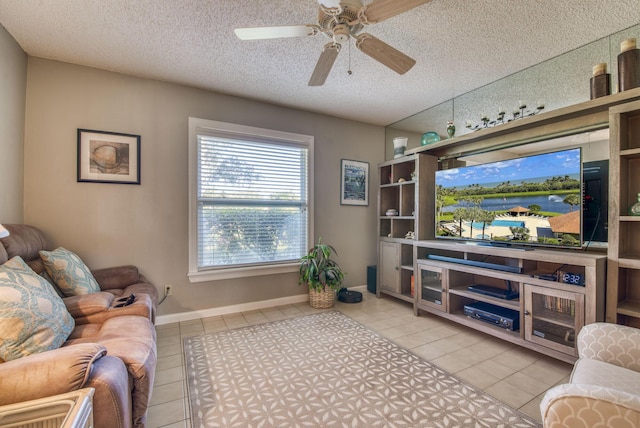 living room featuring light tile patterned floors, ceiling fan, and a textured ceiling
