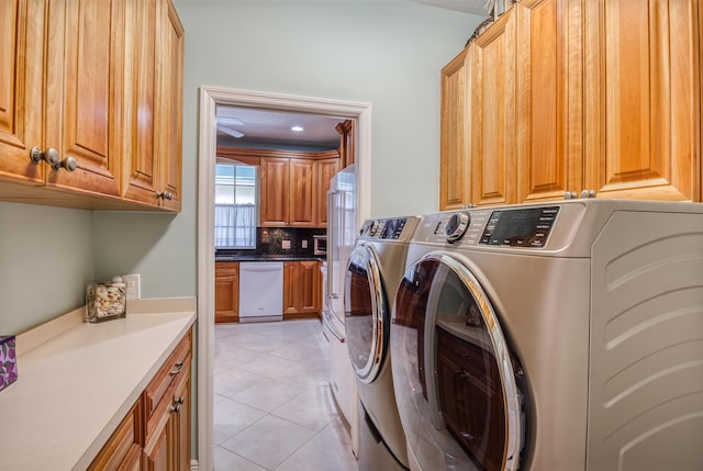 washroom with cabinets, separate washer and dryer, and light tile patterned floors