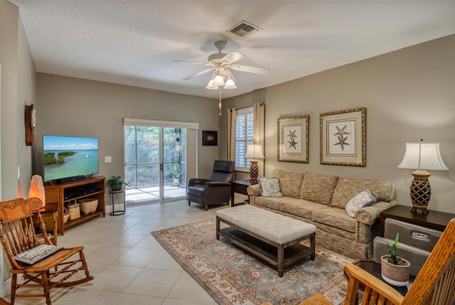 tiled living room featuring a textured ceiling and ceiling fan