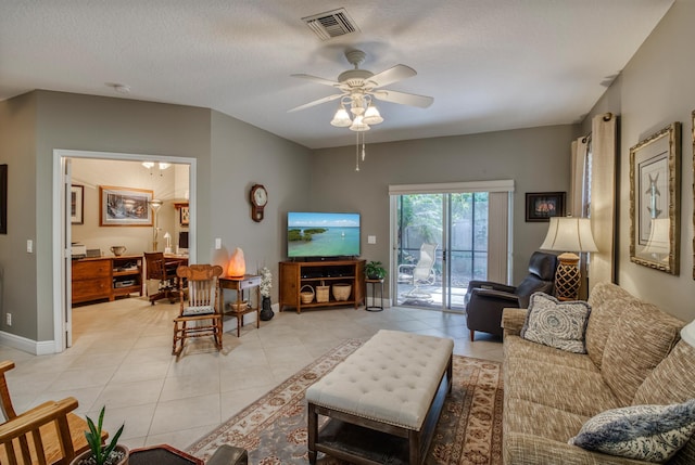 living room featuring light tile patterned floors, a textured ceiling, and ceiling fan