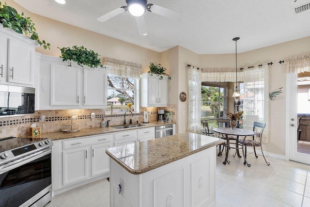 kitchen featuring white cabinets, a center island, stainless steel appliances, and sink