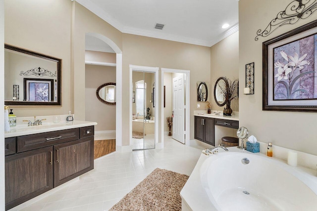 bathroom with vanity, tiled bath, tile patterned floors, and ornamental molding