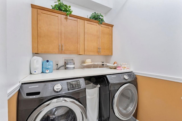 laundry room featuring cabinets and washing machine and dryer