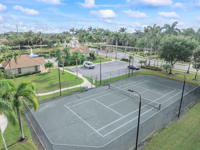 view of tennis court featuring a yard