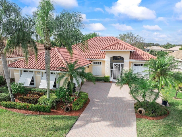 mediterranean / spanish house with a front yard and a garage