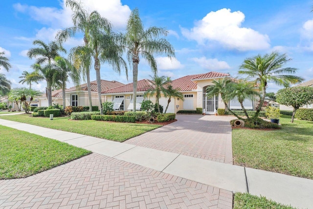 mediterranean / spanish-style home featuring a garage and a front lawn