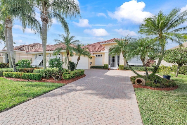 mediterranean / spanish house featuring a garage and a front lawn