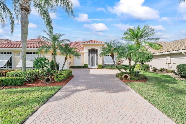 mediterranean / spanish-style home featuring a front yard and a garage