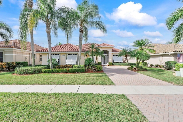 mediterranean / spanish home with a front lawn