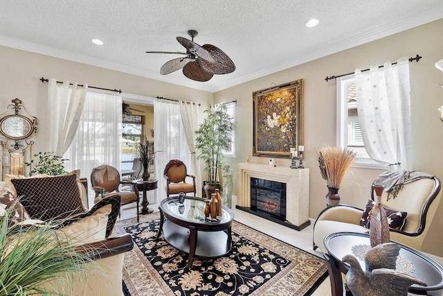 living area with a textured ceiling, ceiling fan, and a healthy amount of sunlight