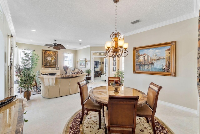 dining space featuring ceiling fan with notable chandelier, light tile patterned floors, a textured ceiling, and crown molding