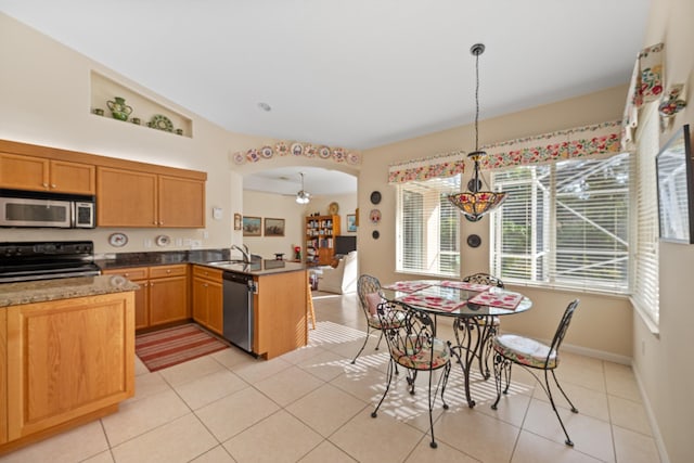 kitchen featuring light tile patterned floors, hanging light fixtures, appliances with stainless steel finishes, and kitchen peninsula