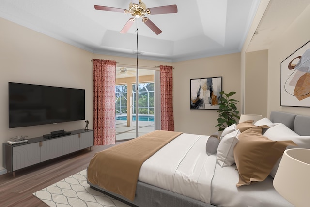 bedroom featuring ceiling fan, access to outside, a raised ceiling, hardwood / wood-style flooring, and crown molding