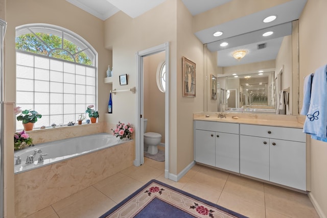 bathroom with tiled tub, toilet, vanity, and tile patterned flooring