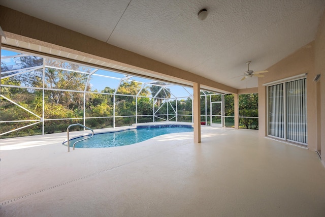 view of swimming pool with a lanai, ceiling fan, and a patio