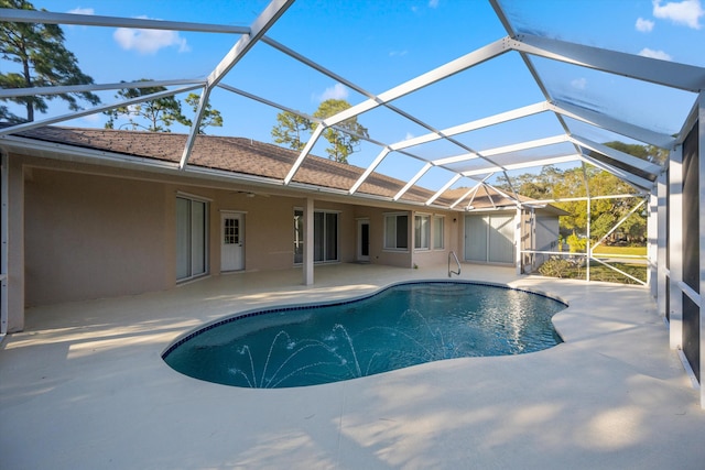 view of swimming pool with glass enclosure and a patio area