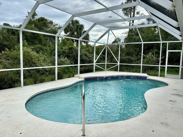 view of swimming pool featuring a patio area and glass enclosure