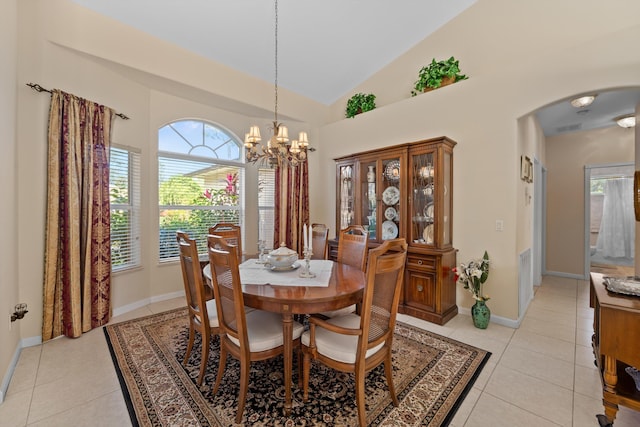 dining area featuring light tile patterned floors, a chandelier, and high vaulted ceiling