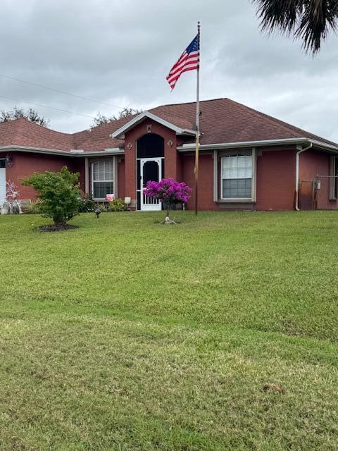 single story home featuring a front yard