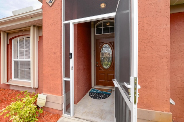 view of exterior entry with stucco siding