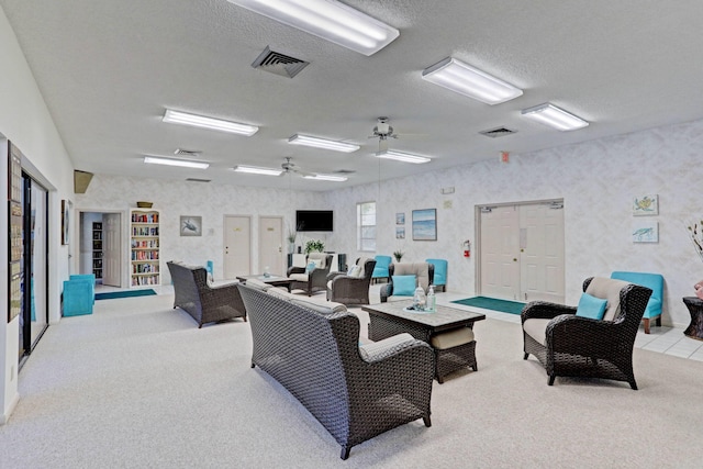 interior space with ceiling fan, light carpet, and a textured ceiling