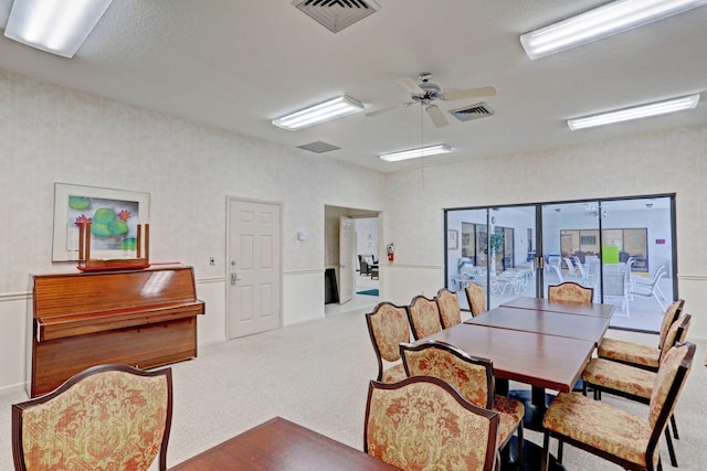 carpeted dining space featuring ceiling fan and a textured ceiling