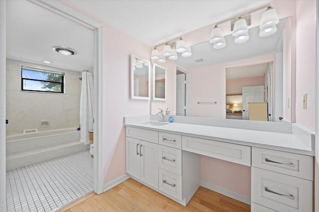 bathroom with hardwood / wood-style floors, shower / bath combination with curtain, and vanity