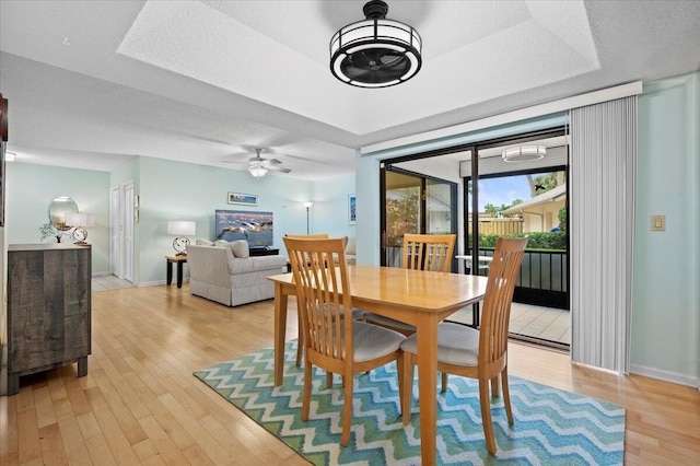 dining space with ceiling fan and light hardwood / wood-style floors