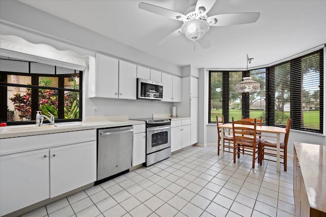 kitchen featuring appliances with stainless steel finishes, ceiling fan, sink, pendant lighting, and white cabinets