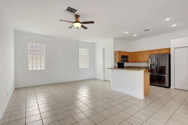 kitchen with a wealth of natural light, ceiling fan, light tile patterned floors, and stainless steel refrigerator with ice dispenser